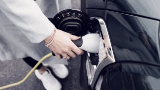 Kvinde lader sin elektriske bil