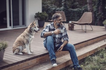 Mand med hund på terrase