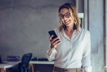 Glad kvinde kigger på sin telefon