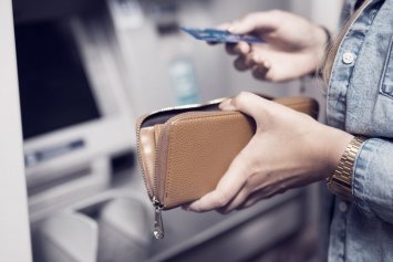 Kvinde hæver penge i pengeautomat