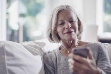 Ældre kvinde kigger på sin telefon