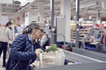 Kvinde ved kassen i supermarked