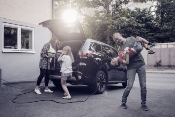 Familie hygger sig foran elbil