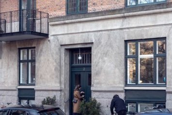 Billede af en opgang til en lejlighed i en grå bygning.