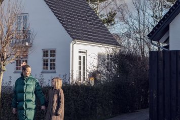 Smukt ældre hvis hus med sorte teglsten fotograferet fra fortovet og ind i haven