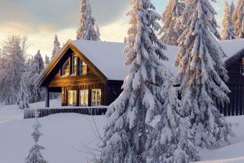 Illustrativt billede af en norsk fjeldhytte omgivet af sne