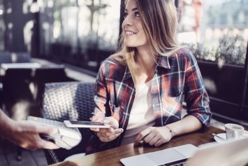 Kvinde betaler med mobiltelefonen