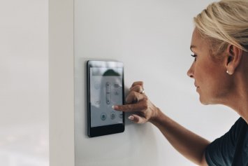 Kvinde skruer ned for digital termostat