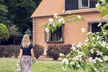Kvinde i have foran hus
