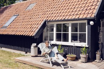 kvinde foran sommerhus
